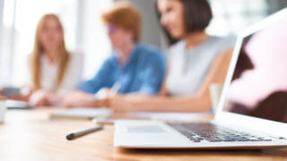 Writing meeting minutes with laptop